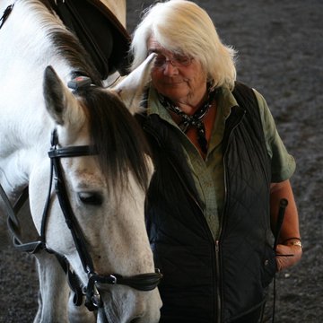 Bernadette Genua, research and equine manager, with a grey horse